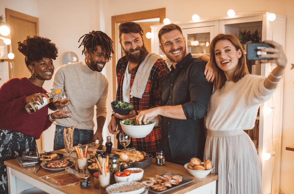 People at a party standing around a kitchen island and talking