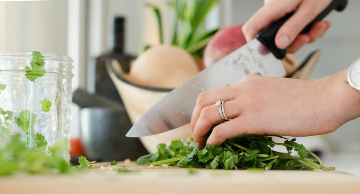 Woman chopping herbs with a chef's knife