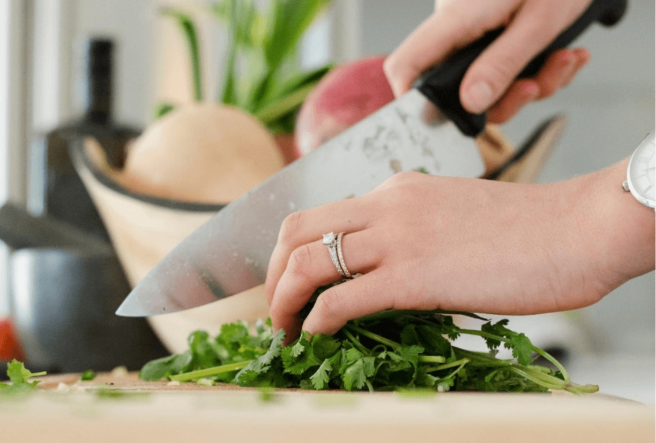 Woman chopping herbs with a chef's knife