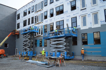 A view of the back of Building D, where siding is going up.