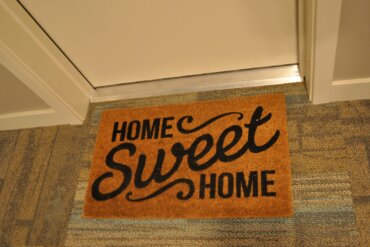 Photo of welcome mat in front of an apartment door.