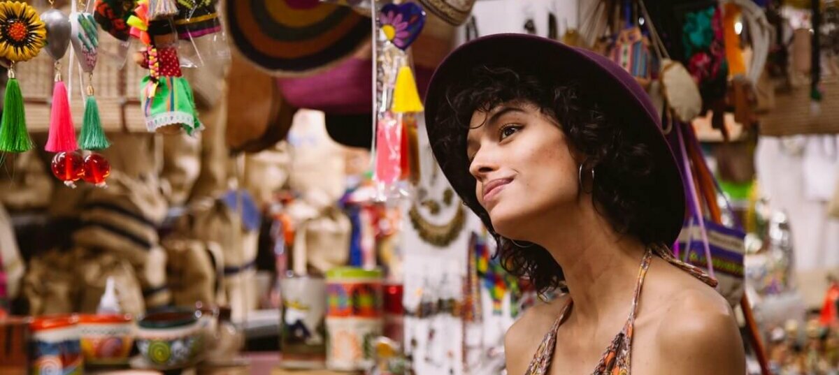 Woman looking at souvenirs in a shop. Image credit: los Muertos Crew