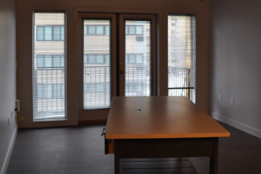 A rolling kitchen island is being placed in this one-bedroom apartment (unit 1C) in Building A