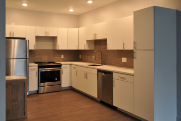 Appliances are being installed in the kitchen of this one-bedroom townhome (Unit T1A) in Building A