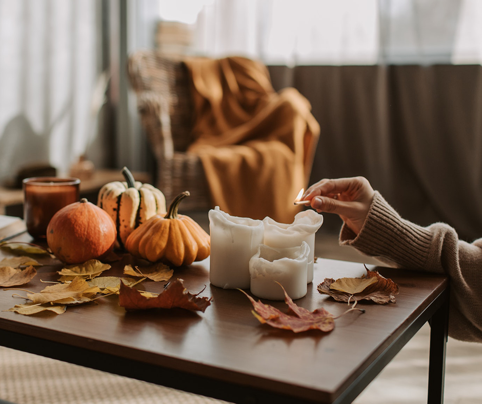 Pumpkins, fall leaves, and candles on a coffee table. Image credit: Vlada Karpovich